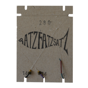 Eine fischförmige braune Pappkarte mit der Aufschrift „RatzFatzSatz 280 (Schwarz & Violett)“ mit zwei mit einer Schnur befestigten Angelhaken und den unter jedem Haken aufgedruckten Zahlen „14“ und „16“ mit schwarzen und violetten Akzenten.