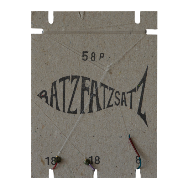 Der RatzFatzSatz 588 (Rot & Violett) besteht aus einem fischförmigen Kartonhalter mit der Aufschrift „BATZFATZSATZ“, den Nummern 58, 18 und 8 sowie drei Angelhaken an Schnüren – hervorgehoben in lebendigen Rot- und Violetttönen.