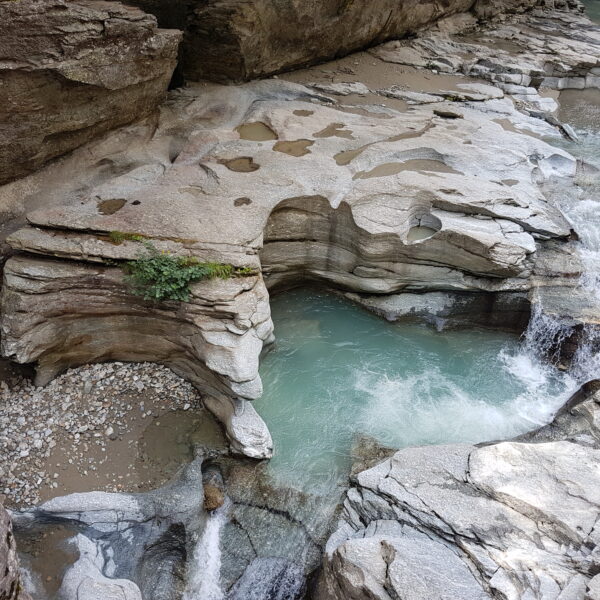 Klares Wasserbecken zwischen Felsen in Cavagliasch. Natürliche Felsformationen und Wasserfall.