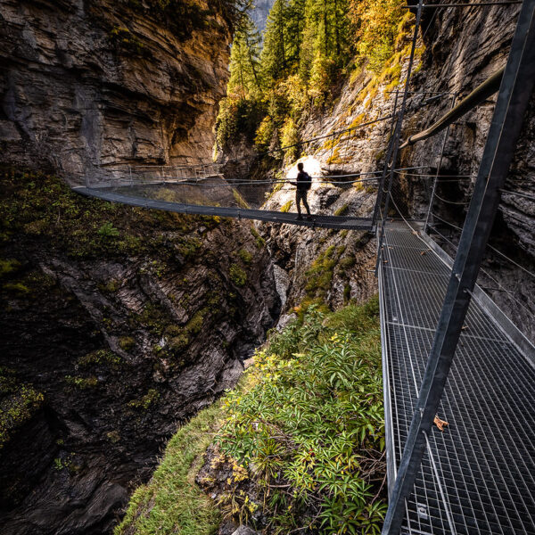 Person überquert die Hängebrücke im Dala-Canyon, Schweiz. Spektakuläre Schluchtansicht.