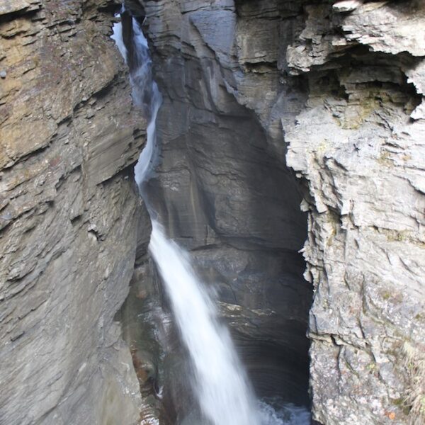 Wasserfall stürzt durch eine enge Felsschlucht.