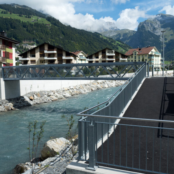 Brücke über die Engelberger Aa mit Häusern und Bergen im Hintergrund.