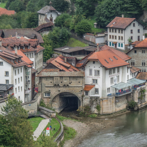 Galtera (Gottéron): Blick auf die mittelalterliche Architektur in Fribourg mit Fluss und Häusern.