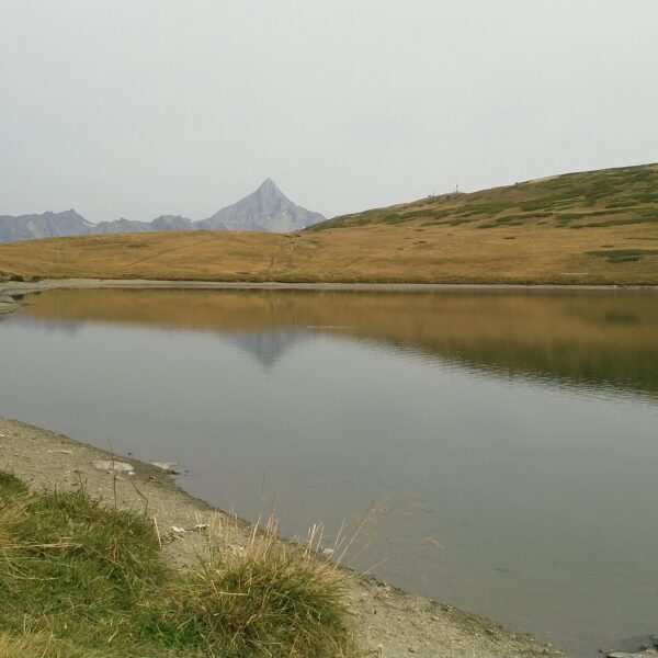 Gibidumsee: Ruhiger Bergsee mit Spiegelung eines Berges im Wasser.