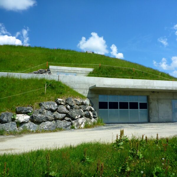 Hintere Hütte Speichersee: Gebäude im Gras eingebettet, mit Garage und Steinen.