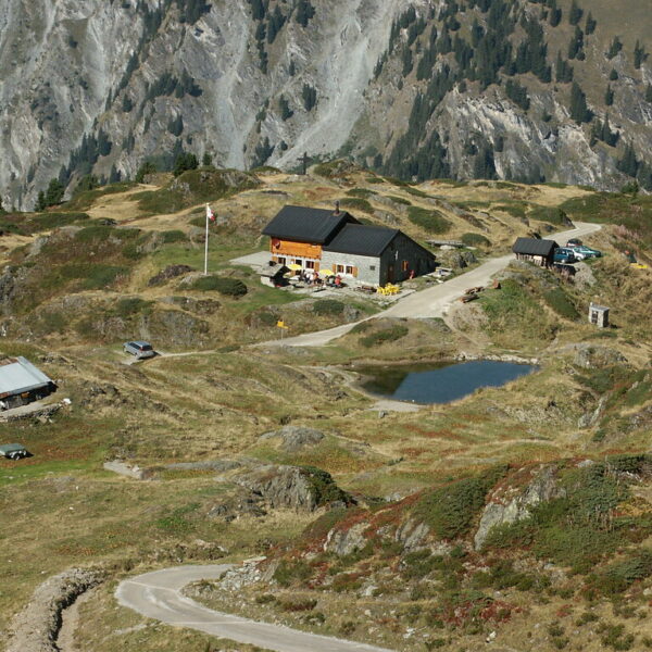 Berglandschaft mit Berghütte am Lac Brunet, Schweiz. Wanderweg im Vordergrund.