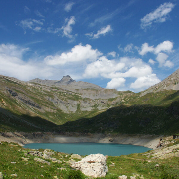 Lac Supérieur de Fully: Bergsee in den Schweizer Alpen unter blauem Himmel mit Wolken.