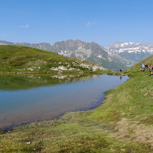 Malerischer Lac de Catogne mit Wanderern und Alpenpanorama im Sommer.