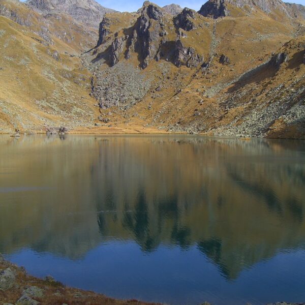 Lac de Louvie: Ruhiger Bergsee mit Spiegelung der umliegenden Gipfel im Wallis, Schweiz.