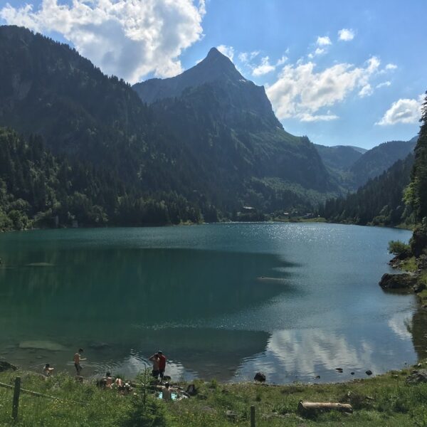 Lac de Tanay mit Bergkulisse und Menschen am Ufer. Ruhiger Bergsee in den Alpen.