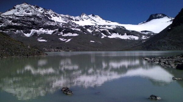 Lac du Grand Désert: Bergsee mit Schneebergen im Hintergrund.