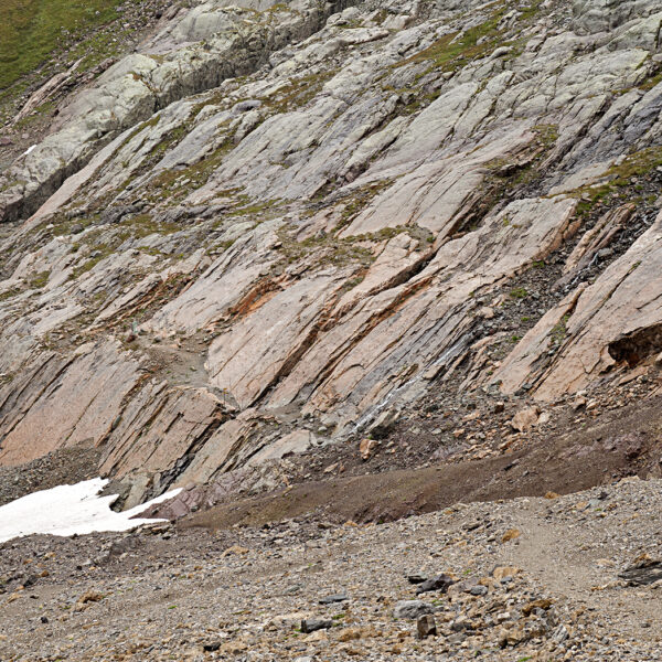 Felsige Landschaft am Lac du Vieux Emosson mit Schnee und Wanderweg.