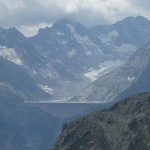 Lägh da l'Albigna Stausee mit Bergen und Gletscher im Hintergrund.