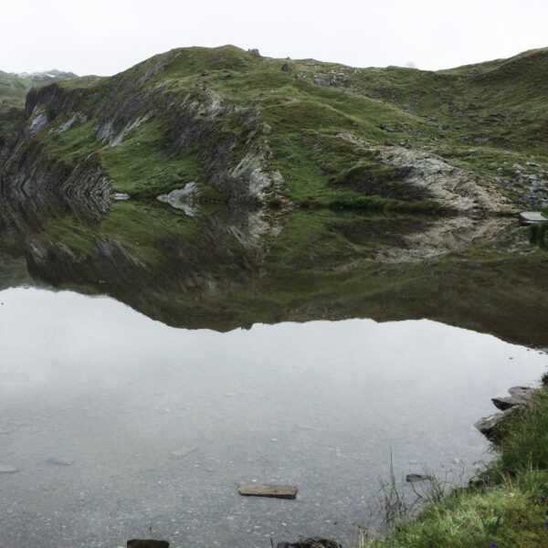 Lämmerensee: Bergsee mit Spiegelung der grünen Hügellandschaft.