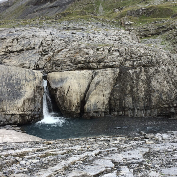 Kleiner Wasserfall in Lämmerendalu, umgeben von Felsen und Geröll.