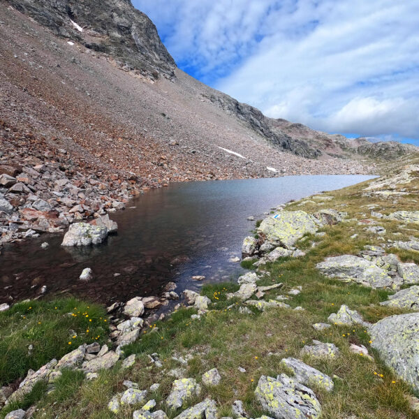 Lej da las Collinas: Bergsee in Graubünden, umgeben von Felsen und alpiner Vegetation.