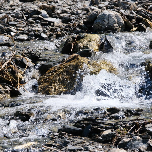 Fließender Bach über Felsen am Nant de Catogne.