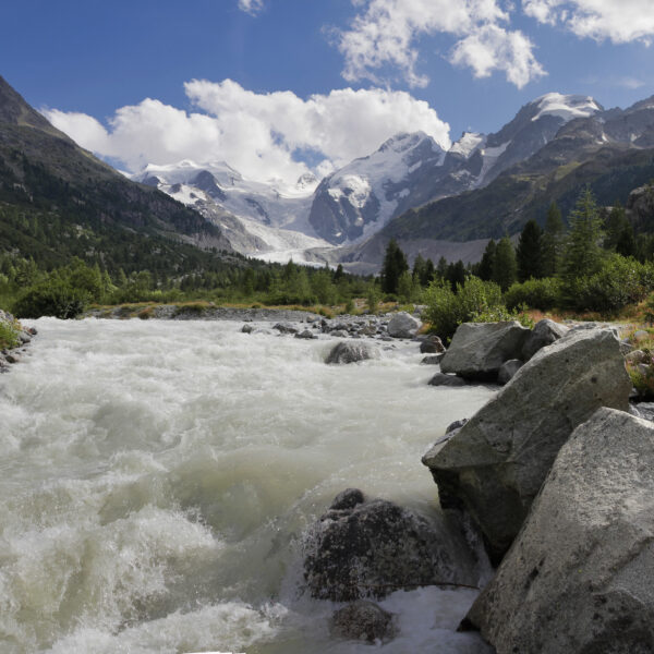 Ova da Morteratsch: Wildbach in den Schweizer Alpen vor schneebedeckten Bergen.