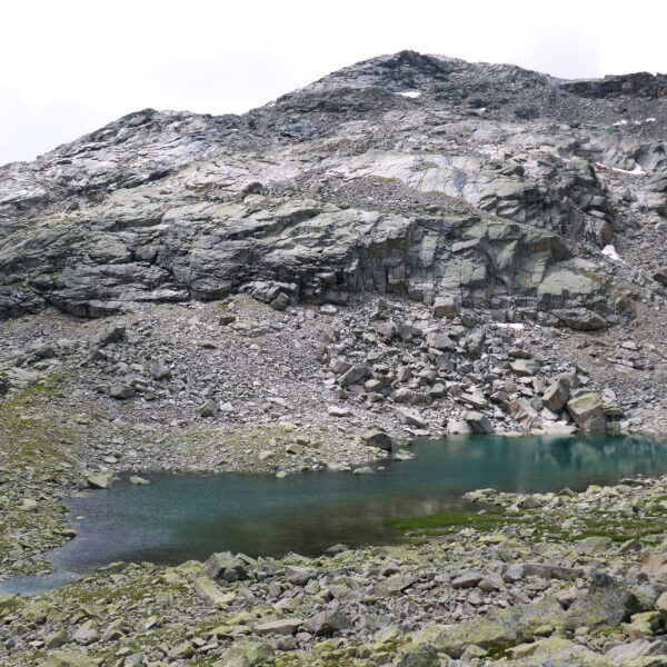 Bergsee Puoz Ot mit felsiger Umgebung und Geröll.