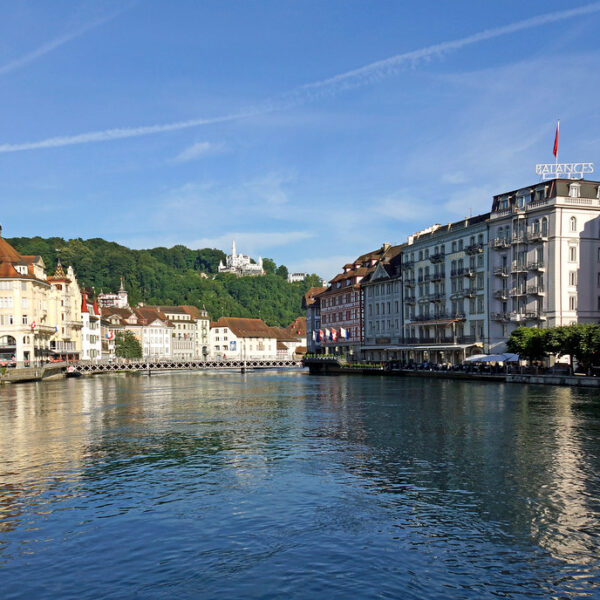 Reuss Fluss in Luzern, Schweiz, mit Blick auf historische Gebäude und blauen Himmel.