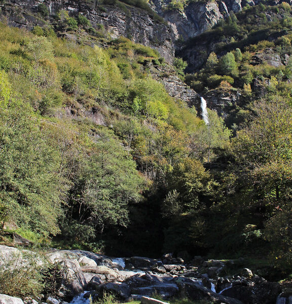 Fluss Ri della Froda in Biasca mit Wasserfall und Bergen im Tessin.
