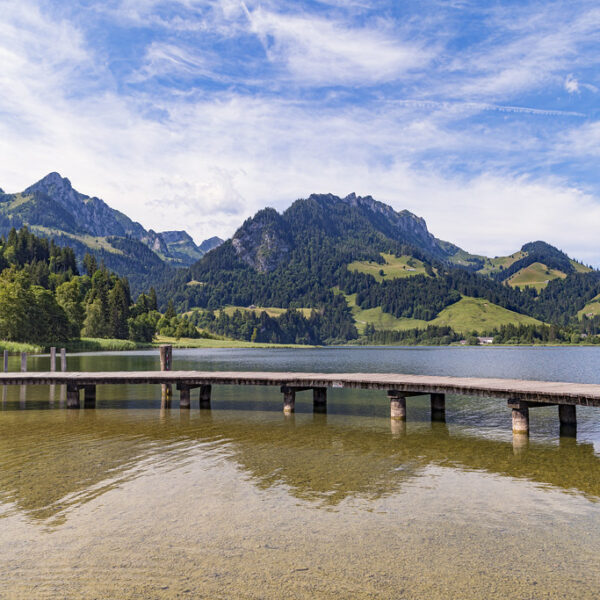 Holzsteg am Schwarzsee mit Blick auf die Berge und den klaren See.