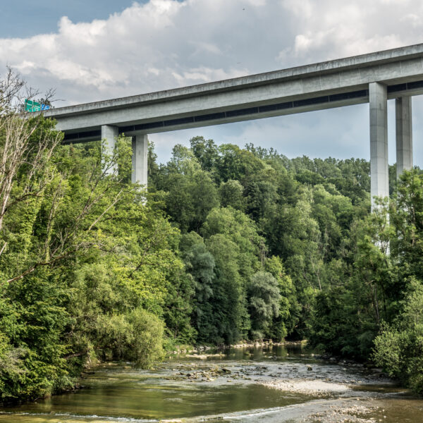 Hohe Autobahnbrücke über den Fluss Sitter, umgeben von üppigem Grün.