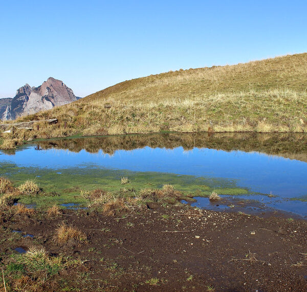 Stoosbach Spiegelung. Bergsee mit Spiegelbild der umliegenden Berge in der Schweiz.