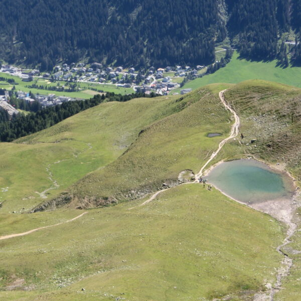 Strelasee Bergsee in Arosa, Schweiz, mit Wanderweg und Blick auf das Dorf.