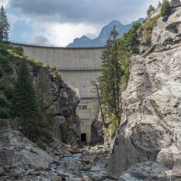 Sufnersee Staumauer: Beeindruckende Betonstruktur in alpiner Landschaft mit Felsen und Bäumen.