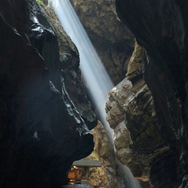Tiefe Schlucht mit Wasserfall und Felswänden im Tamina Tal, Sonnenstrahl fällt ein.