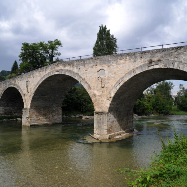 Historische Steinbrücke über den Fluss Töss mit bewölktem Himmel.