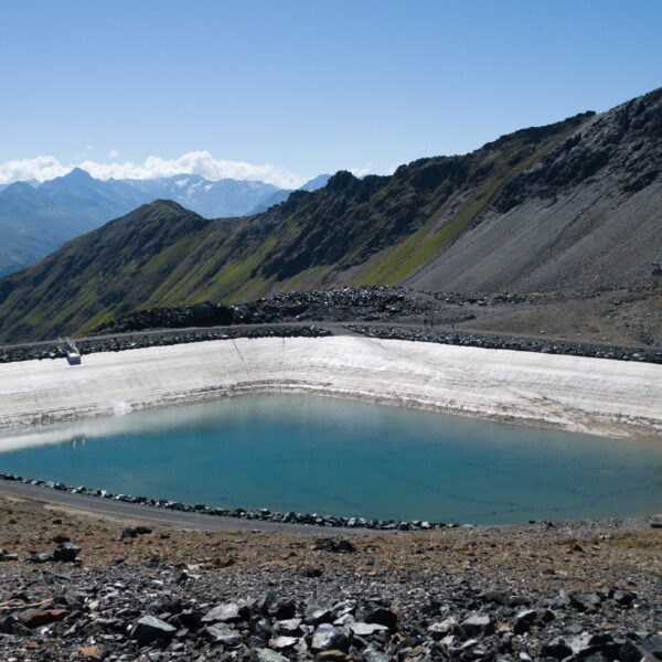 Totalpsee Speichersee in den Alpen. Blauer See mit Bergkulisse im Hintergrund.