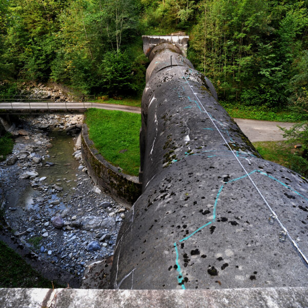 Trepsenbach: Betonrohr über Bachbett mit Brücke und üppigem Grün.