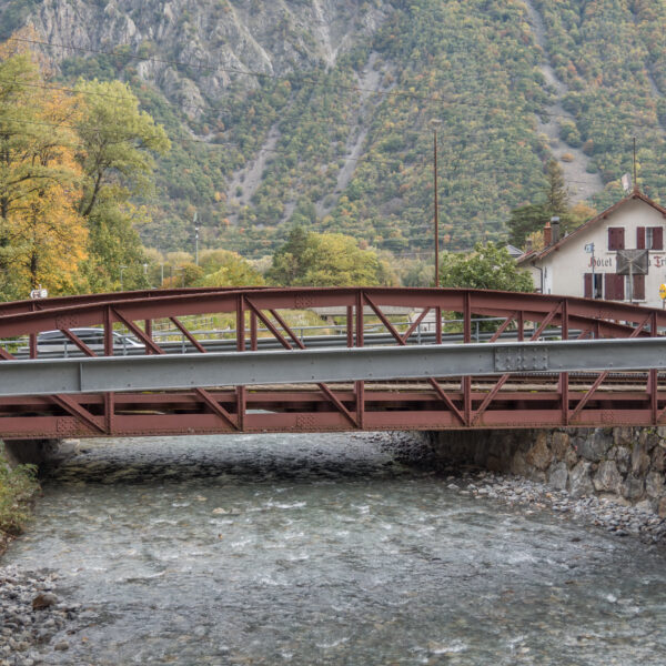 Brücke in Trient, Schweiz, über einen Fluss mit dem Hotel Trient im Hintergrund.