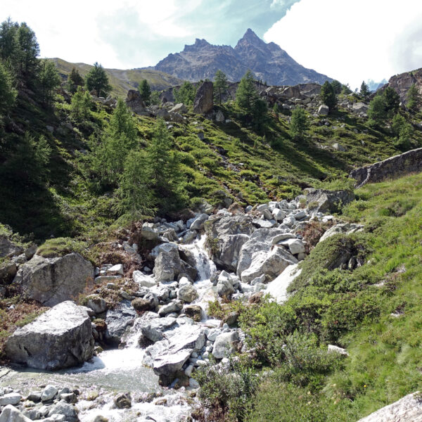 Triftbach bei Zermatt: Berglandschaft mit Bachlauf und Felsen.