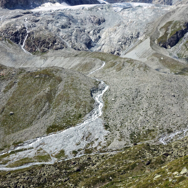Triftbach-Gletscherbach in Zermatt mit Geröllhalden und Eis.
