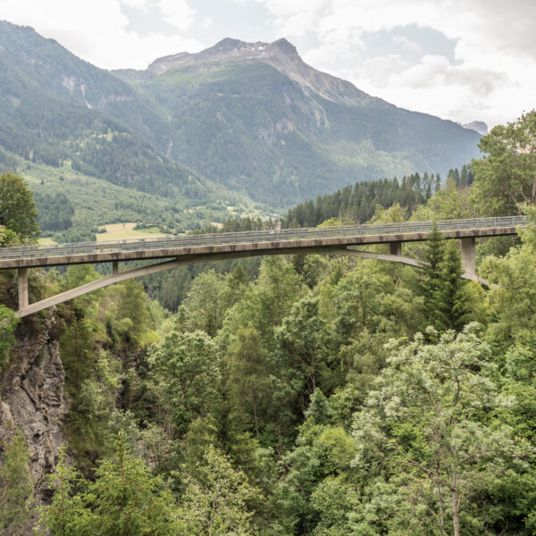 Valtschiel Brücke über grüne Landschaft und Berge.