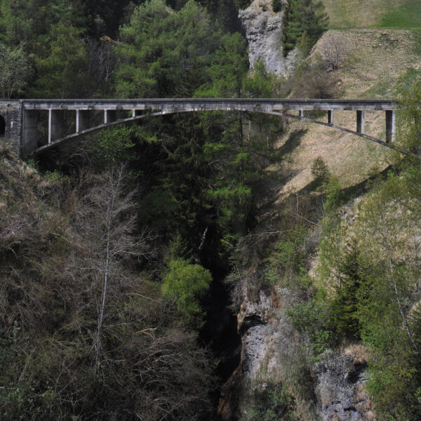 Valtschiel: Betonbrücke überspannt eine tiefe Schlucht, umgeben von Wald und grünen Hängen.