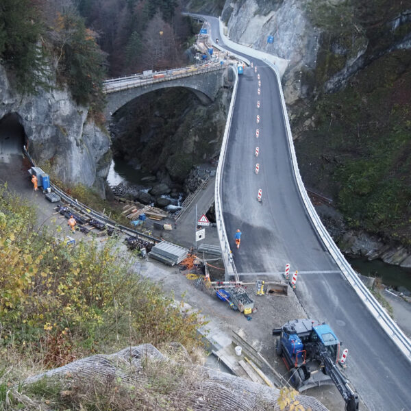 Waldemme: Neue Straße mit Tunnel und Brücke in einer Berglandschaft.