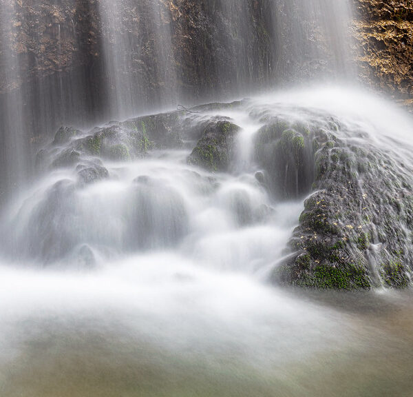 Wasserfall am Wängibach umfließt einen moosbedeckten Felsen.