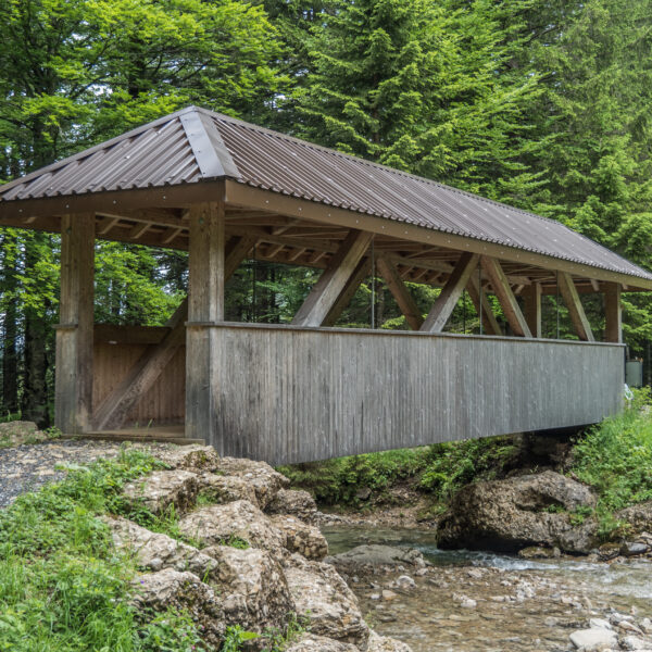 Gedeckte Holzbrücke über den Wängibach, umgeben von Bäumen.