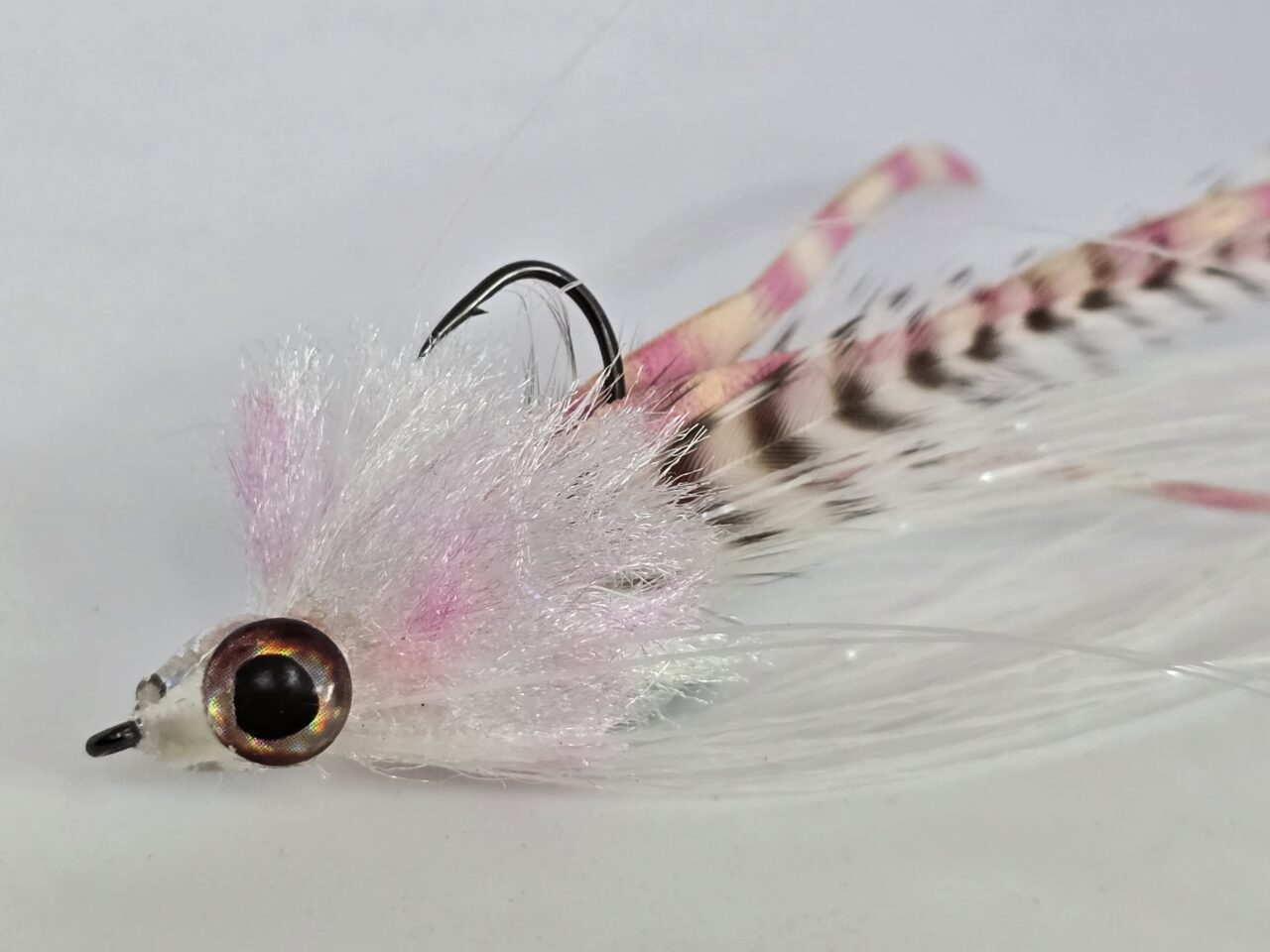 Kunstfliege in Weiß und Rosa mit Haken, ideal zum Fliegenfischen und Fliegenbinden als Ausgleich zum Alltag.