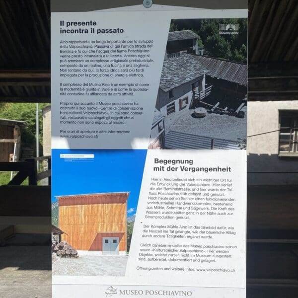 Ein zweisprachiges Informationsschild im Museo Poschiavino enthält italienischen und deutschen Text mit Fotos einer alten Mühle und eines modernen Gebäudes und beschreibt die Geschichte und Bedeutung des Museums.