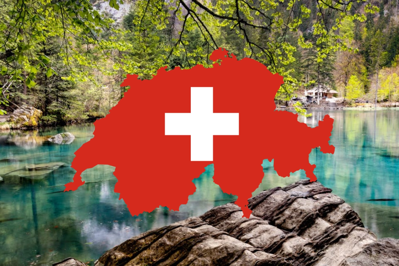 Eine rote Silhouette der Schweiz mit einem weißen Kreuz in der Mitte ist über einen malerischen See gelegt, der von Felsen, Bäumen und Bergen umgeben ist.